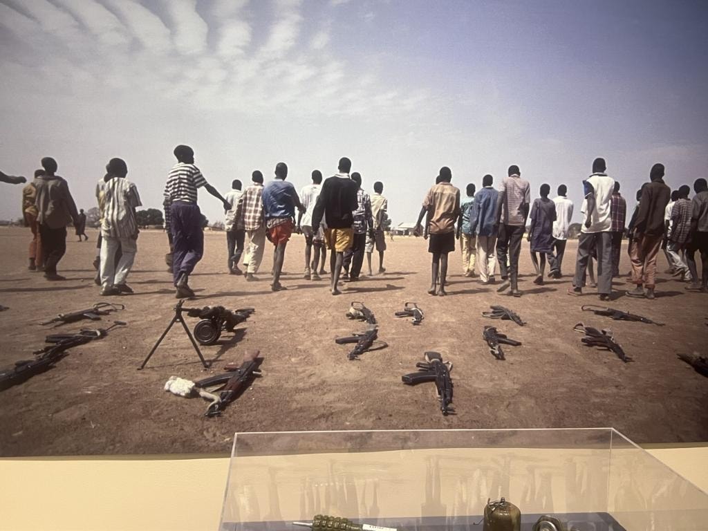 Young people walking away from weapons on the ground — United Nations photo